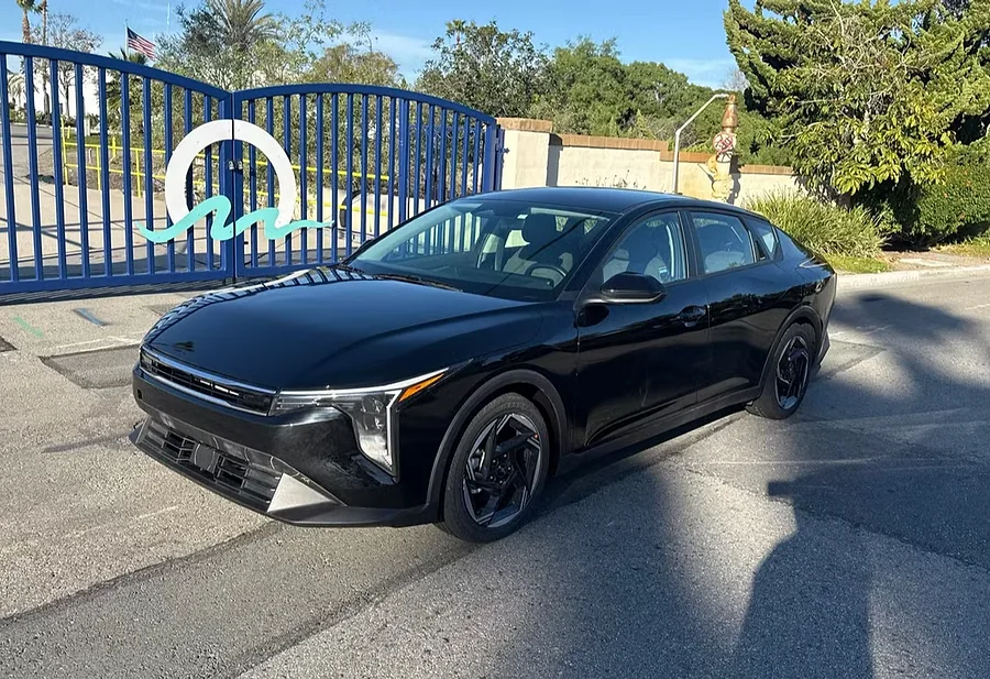 Black Kia K4 sedan parked at the Evolution Auto Sale lot